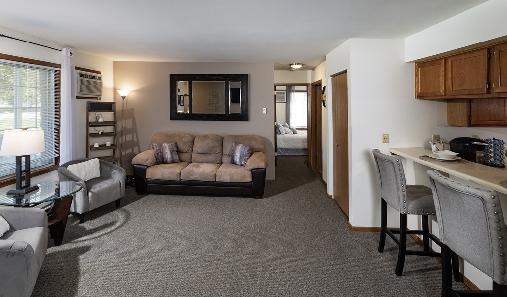 a living room with a couch and a chair and a dining room and a kitchen