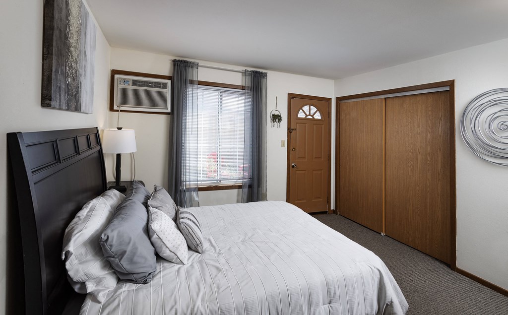 a bedroom with a bed and a dresser and a door