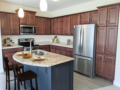 A kitchen with brown cabinets and a granite countertop.
