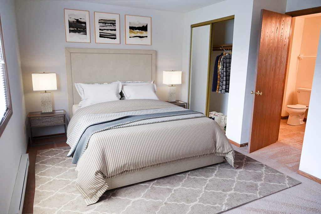 a bedroom with a bed and a closet and a toilet