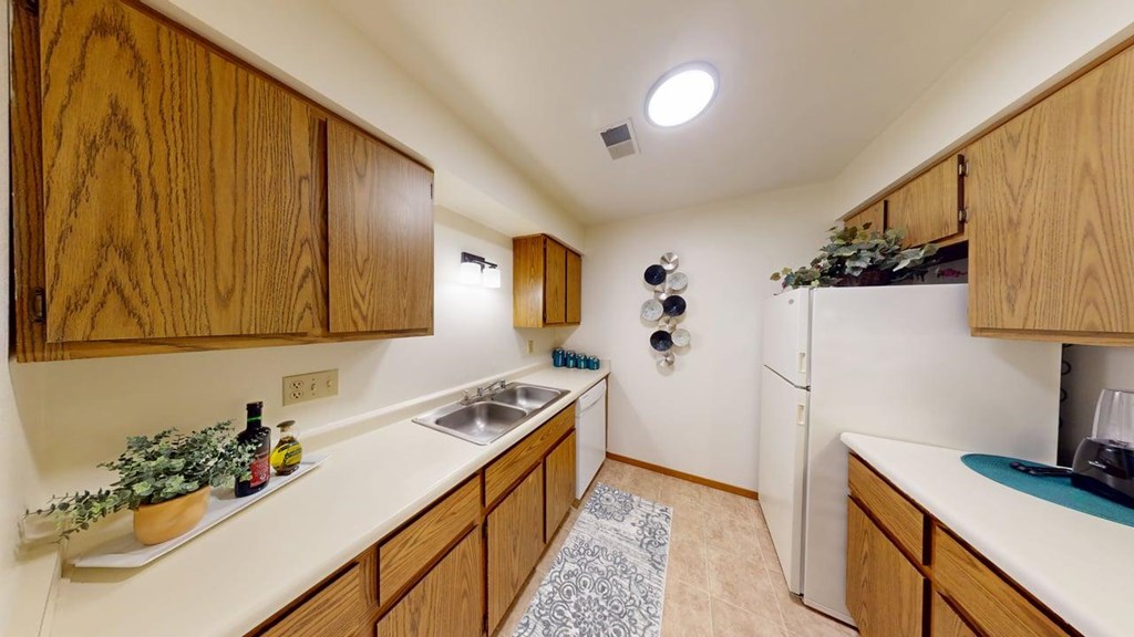 A kitchen with wooden cabinets and a white counter top.