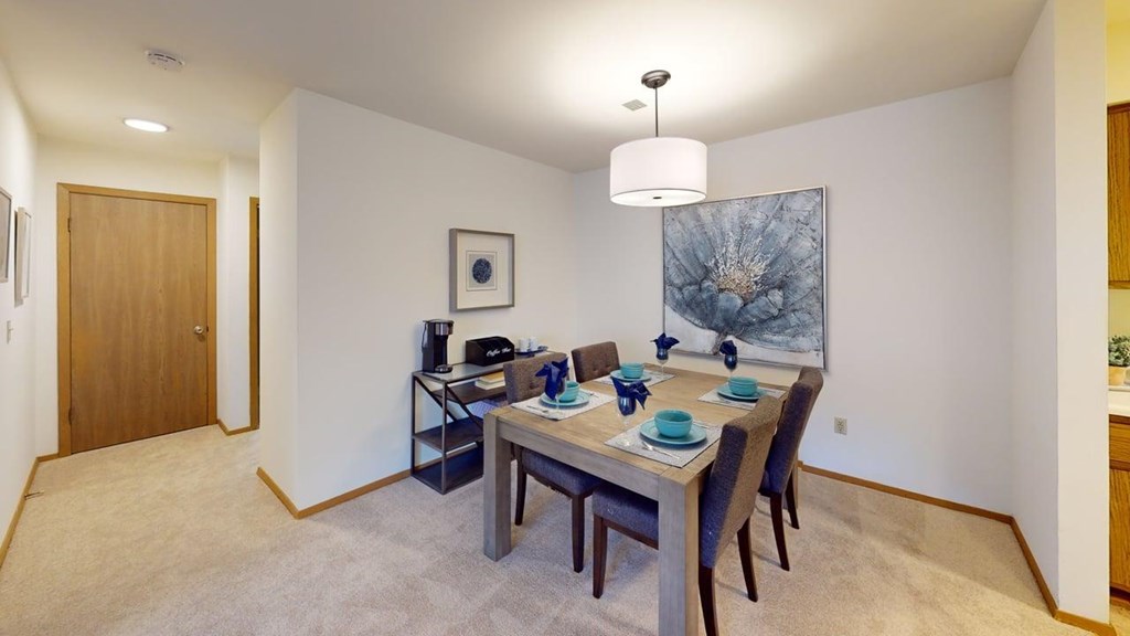 A dining room with a table set for four.