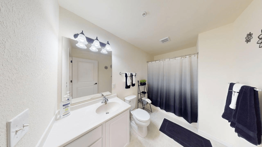 A bathroom with a white sink and a white toilet.