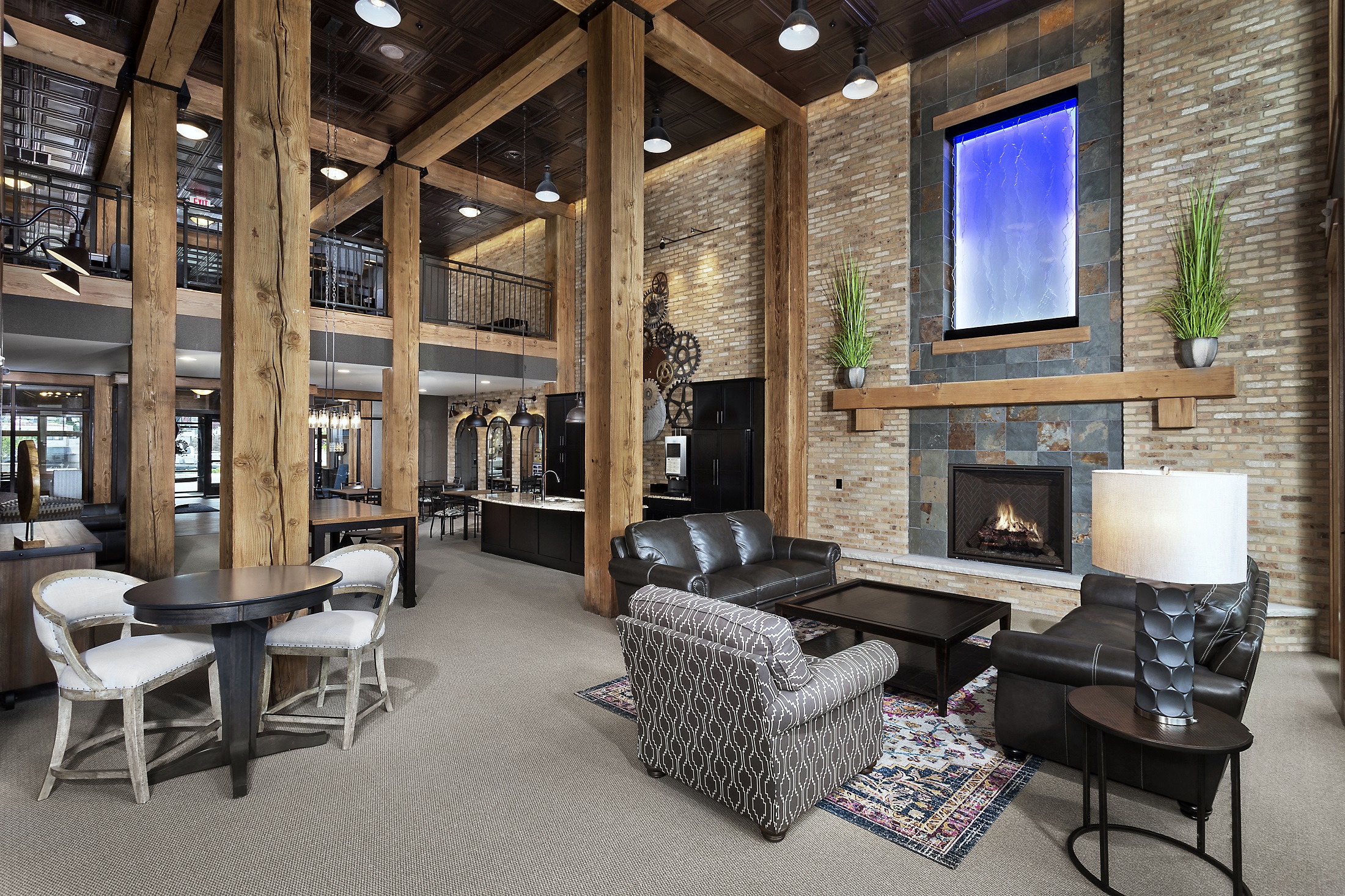 the lobby of a lodge with a fireplace and tables and chairs