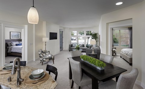 a living room and dining room with a table and chairs