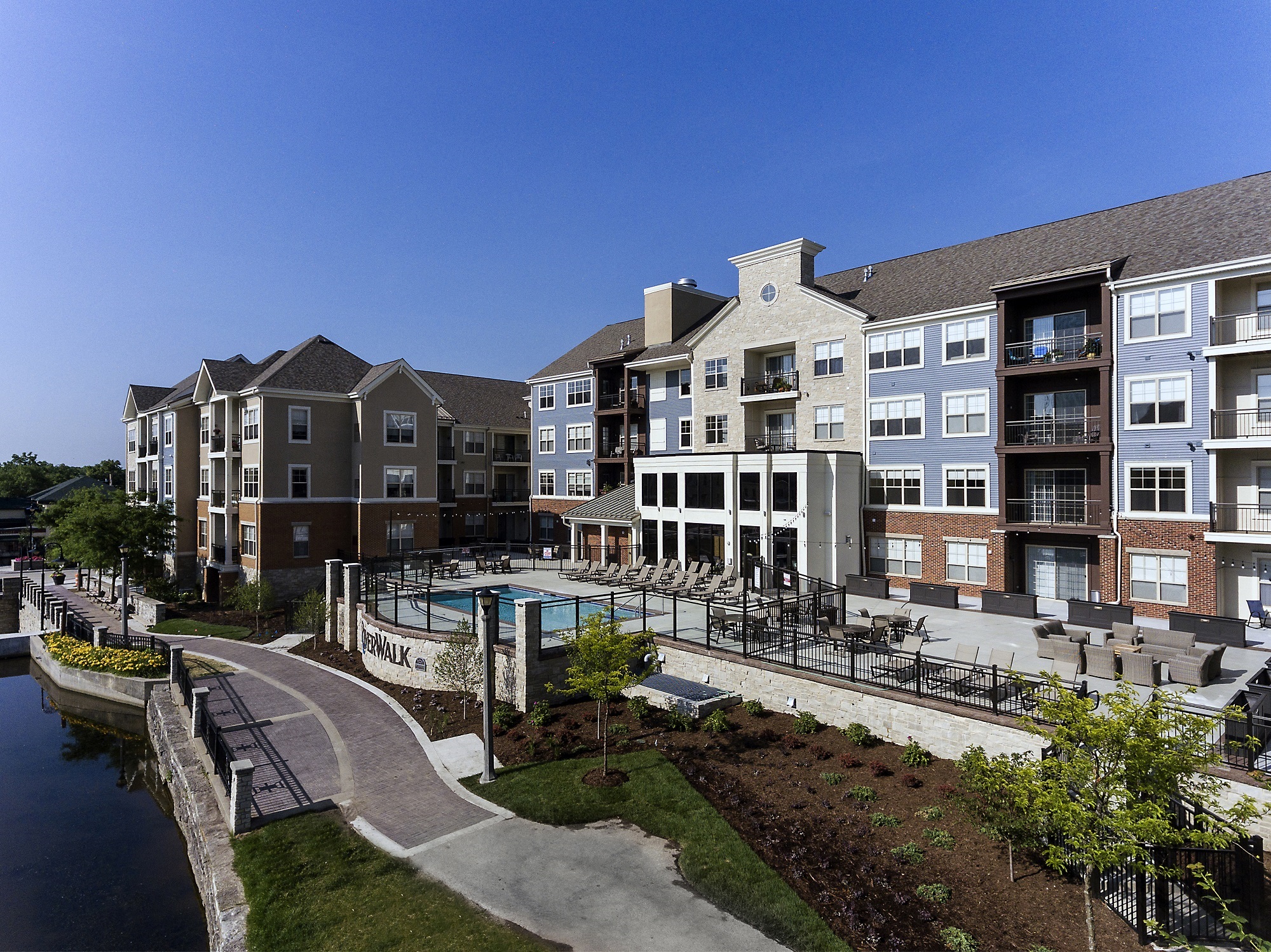 an exterior view of an apartment building with a swimming pool