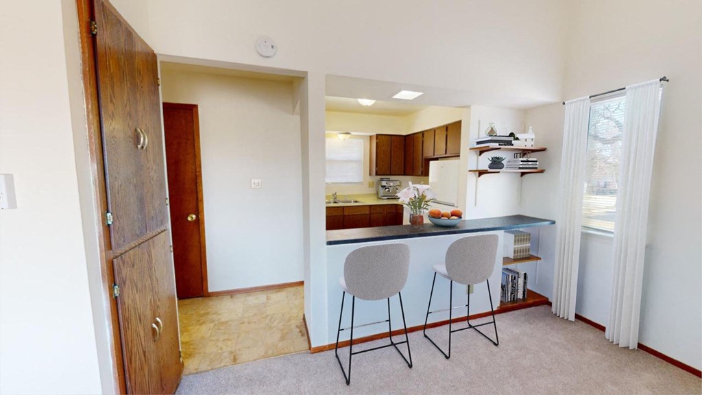 a kitchen with a counter and two stools