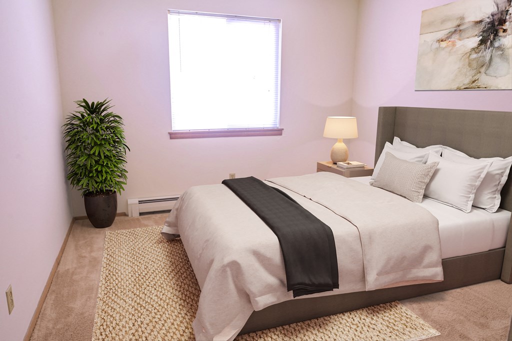 a bedroom with a bed and a pink wall and a window