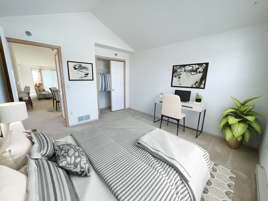 a bedroom with a bed and a desk with a computer