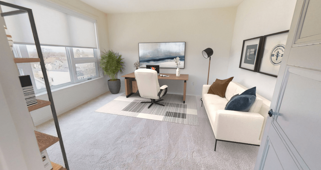 a living room with a couch and a desk and a window
