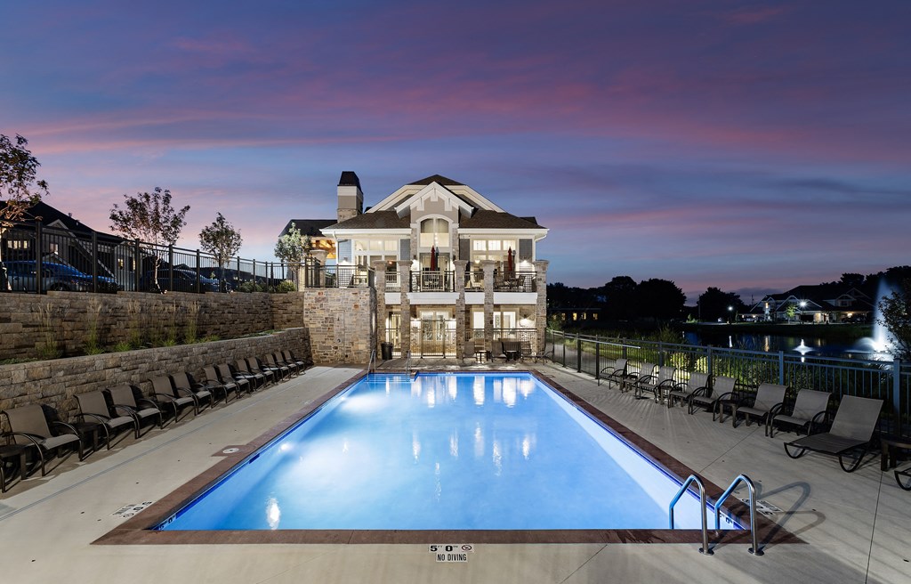 a swimming pool in front of a house with a pool