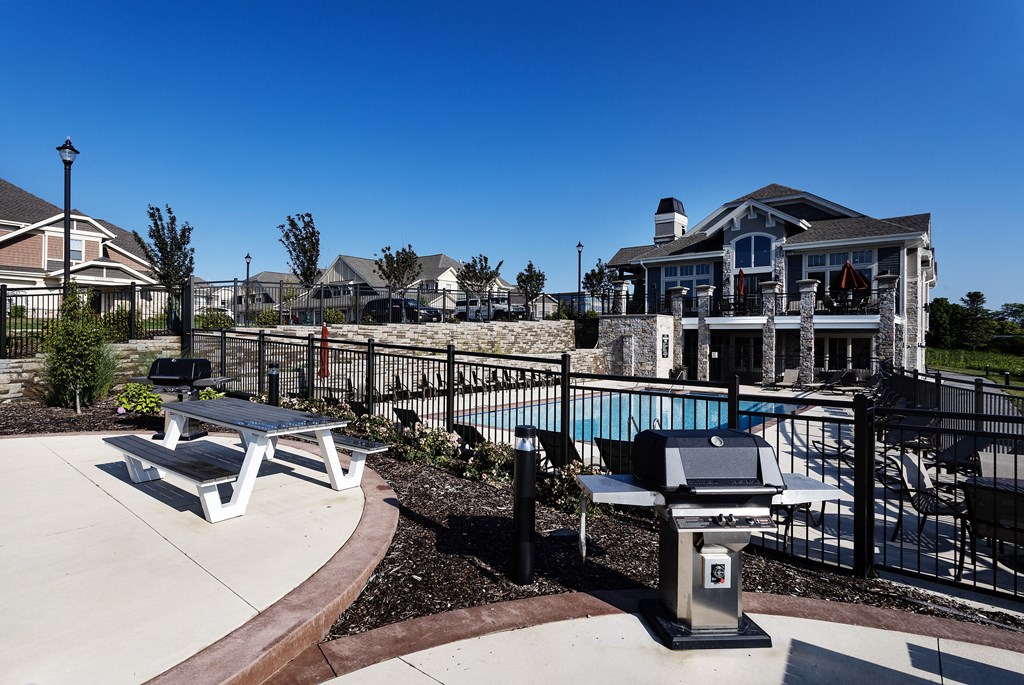 a swimming pool with a picnic table in front of a house