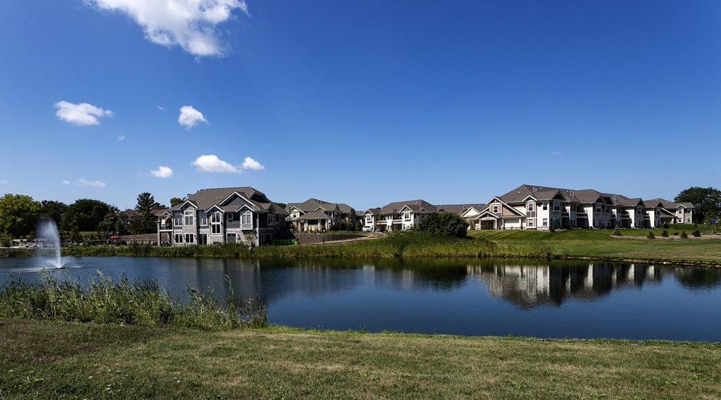 a pond in front of a row of houses