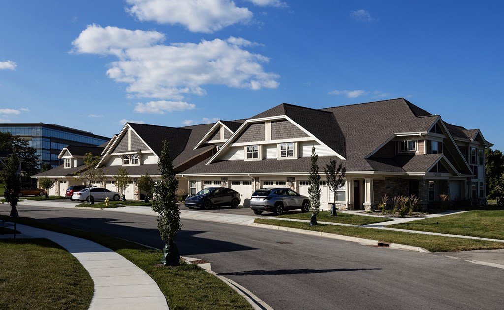 a row of houses with cars parked on a street