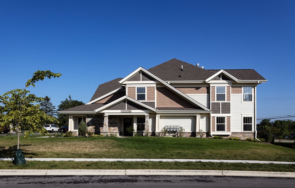a house on the corner of a street with a lawn