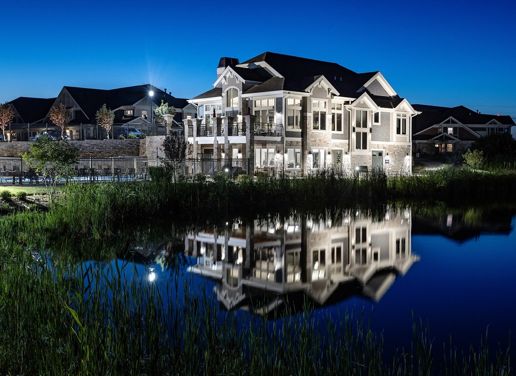 a large building reflected in a pond at night