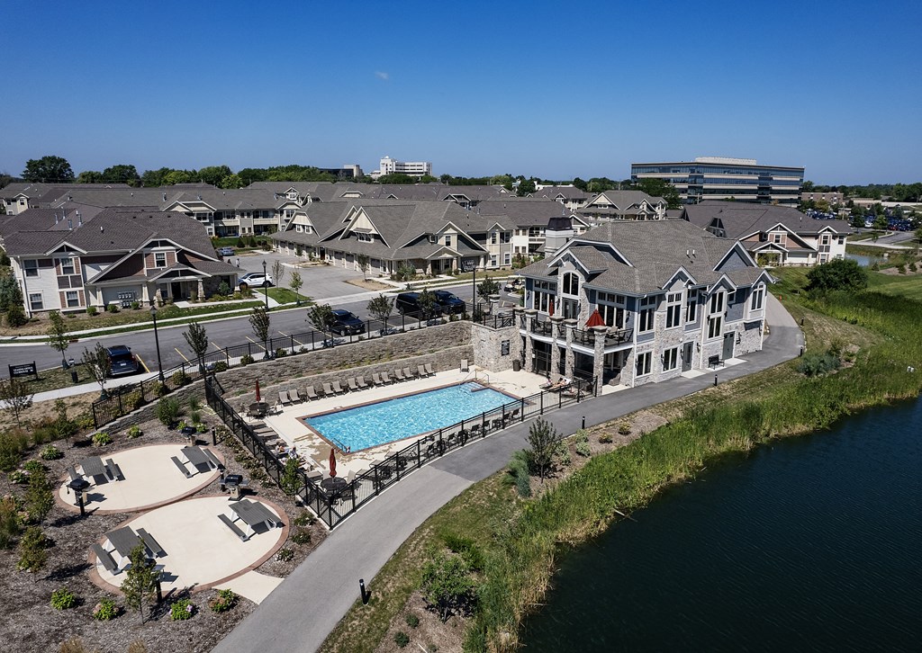 an aerial view of a house with a swimming pool in front of other houses