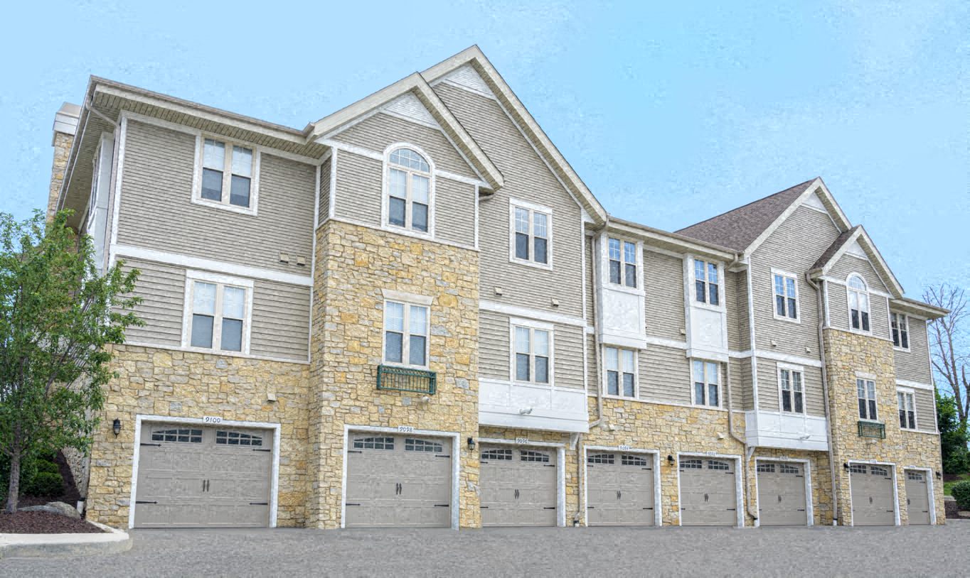 a rendering of a brick apartment building with garages