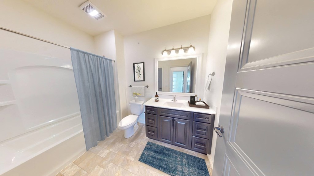 a bathroom with a toilet and a shower and a sink