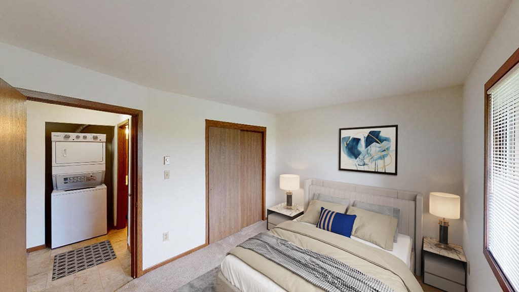 a bedroom with a bed and a door to a kitchen