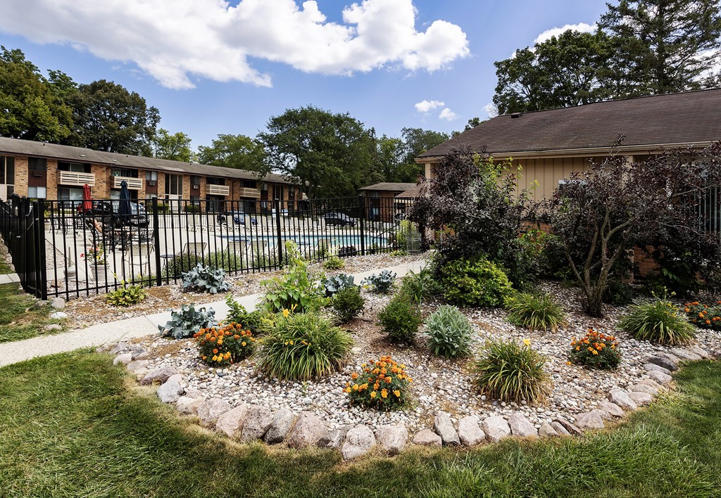 the front yard of a house with a garden and a fence