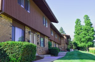 a brown house with a sidewalk in front of it
