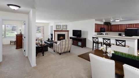 A living room with a fireplace and a dining table.