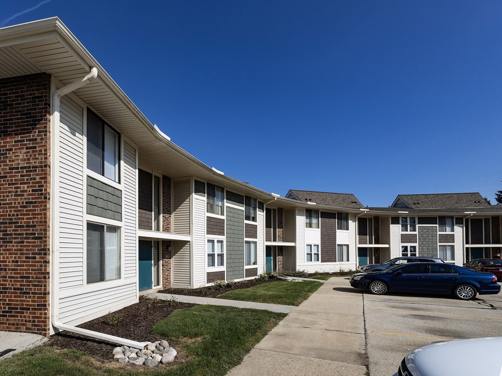 an apartment building with a car parked outside