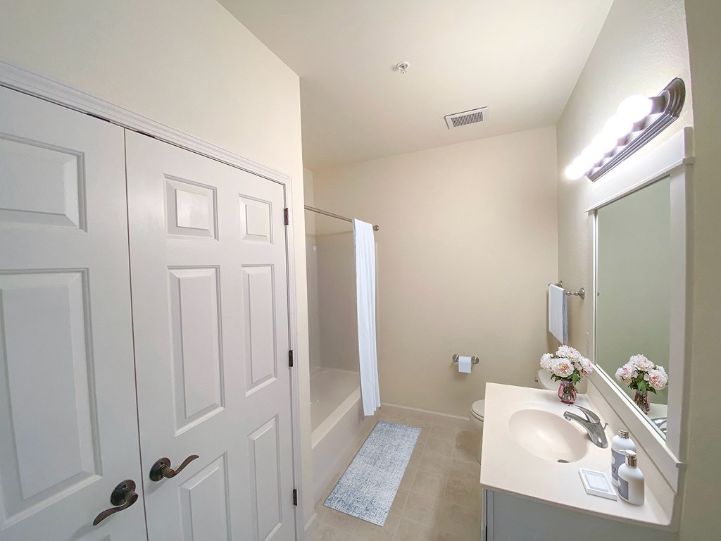 a bathroom with a white door and a sink and a shower