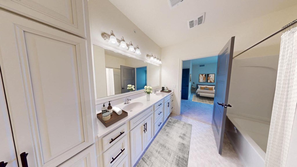 a white and blue bathroom with a shower and a sink