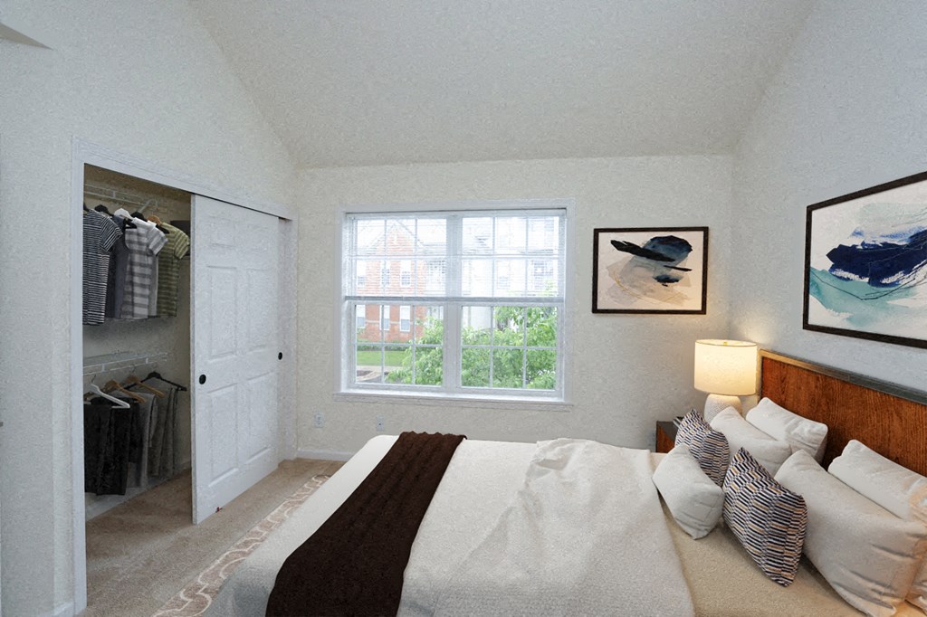 the master bedroom has a walk in closet and a large bed