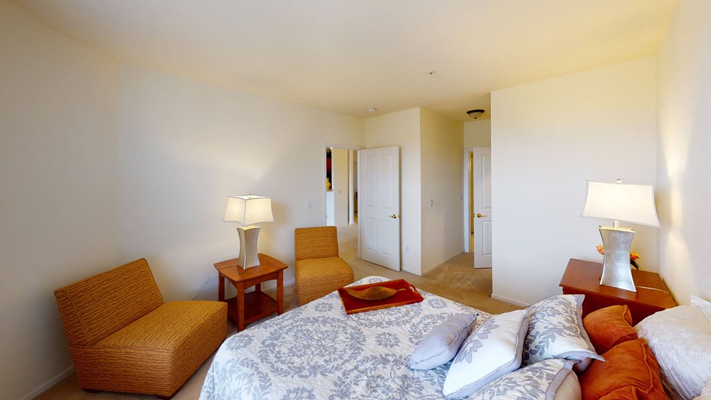 a bedroom with a bed and two chairs