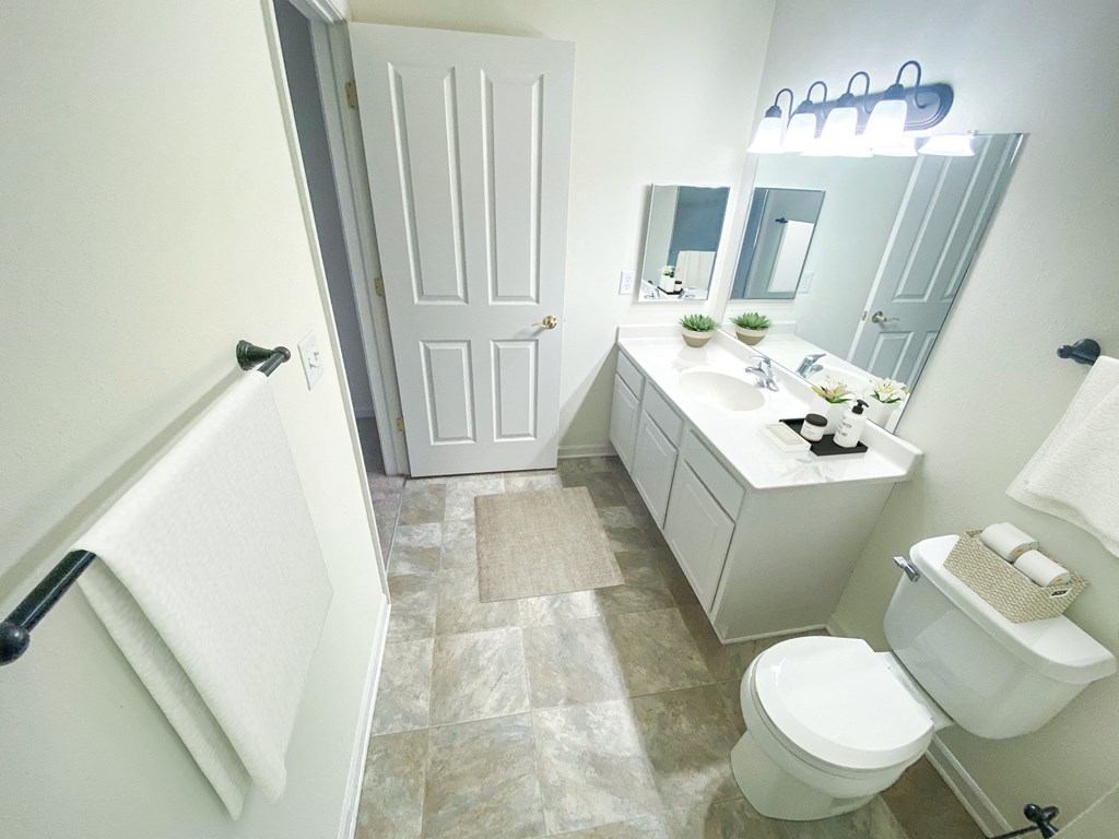 a bathroom with a white toilet next to a white sink