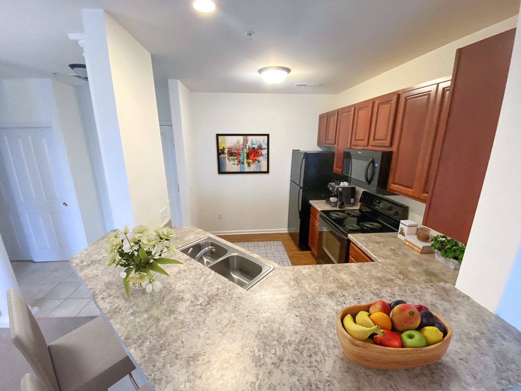 a kitchen with a large island with a bowl of fruit on it
