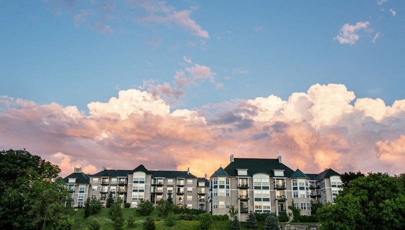 a large apartment building with a cloudy sky in the background