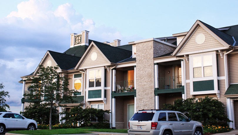 a row of apartment buildings with cars parked in front of them