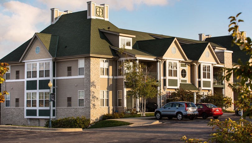 a large apartment building with cars parked in front of it