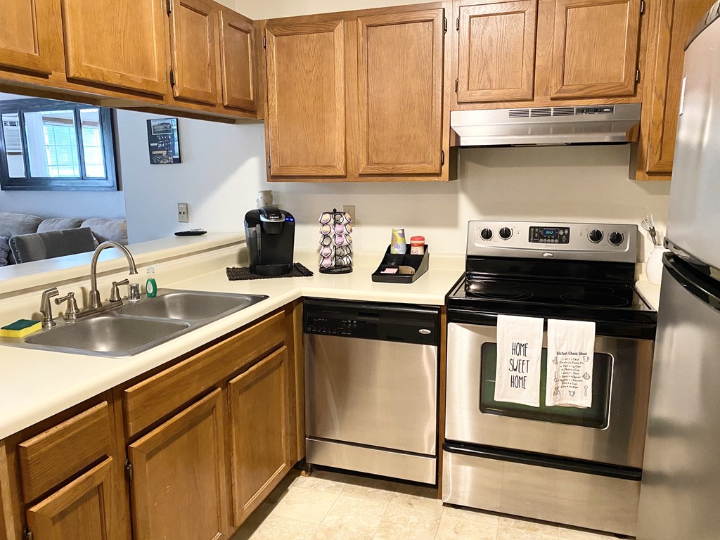 a kitchen with stainless steel appliances and wooden cabinets