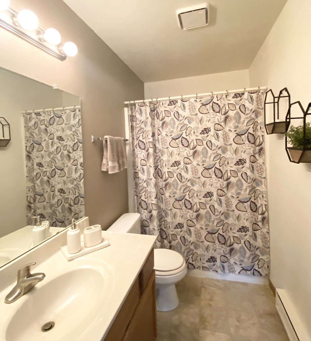 a bathroom with a sink and a shower and a toilet