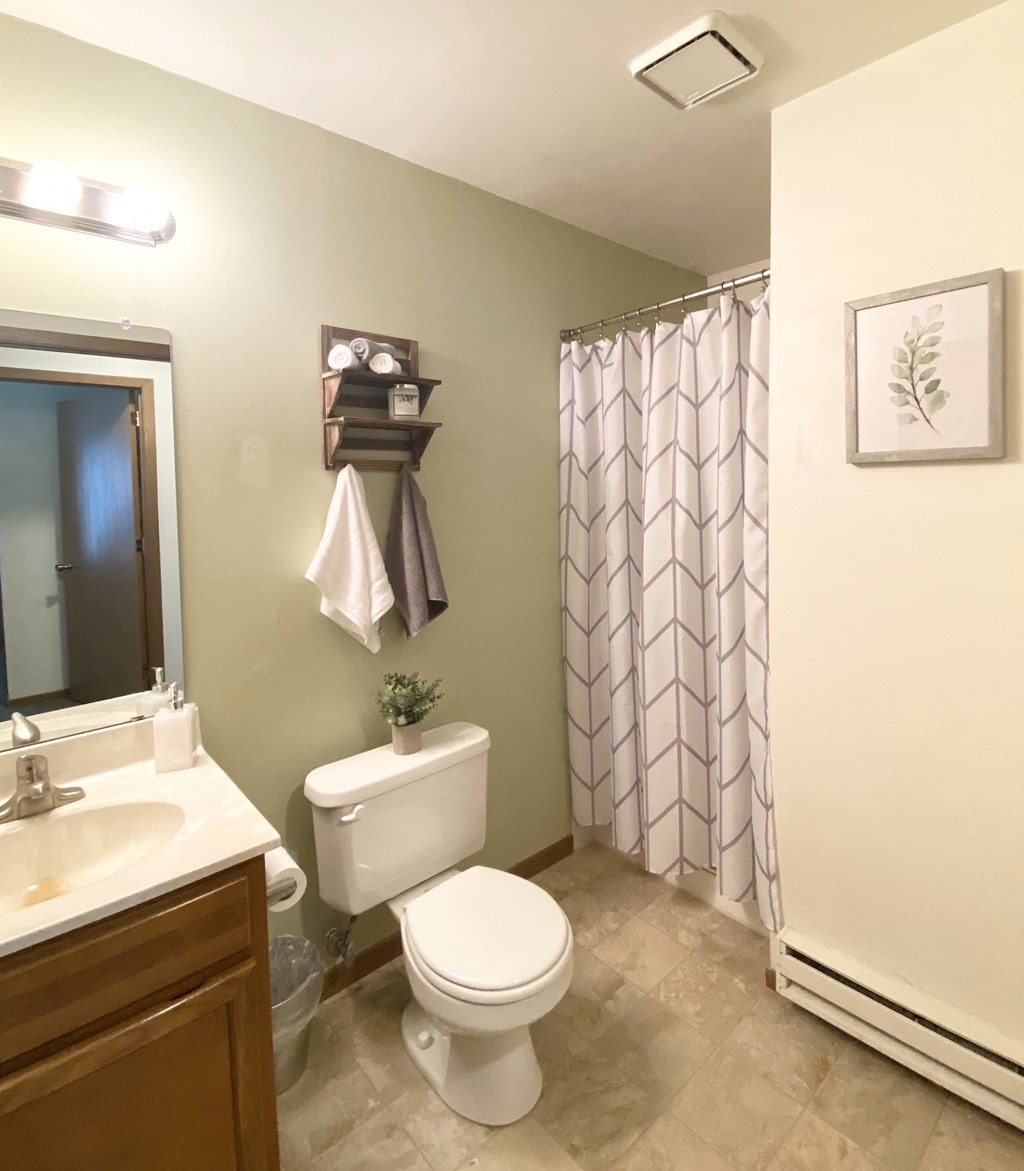 a bathroom with a toilet and a shower and a sink