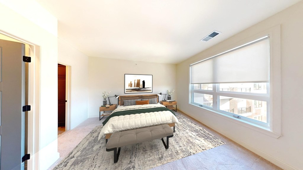 a bedroom with a bed and a large window