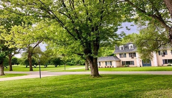 a house on the side of a field with trees