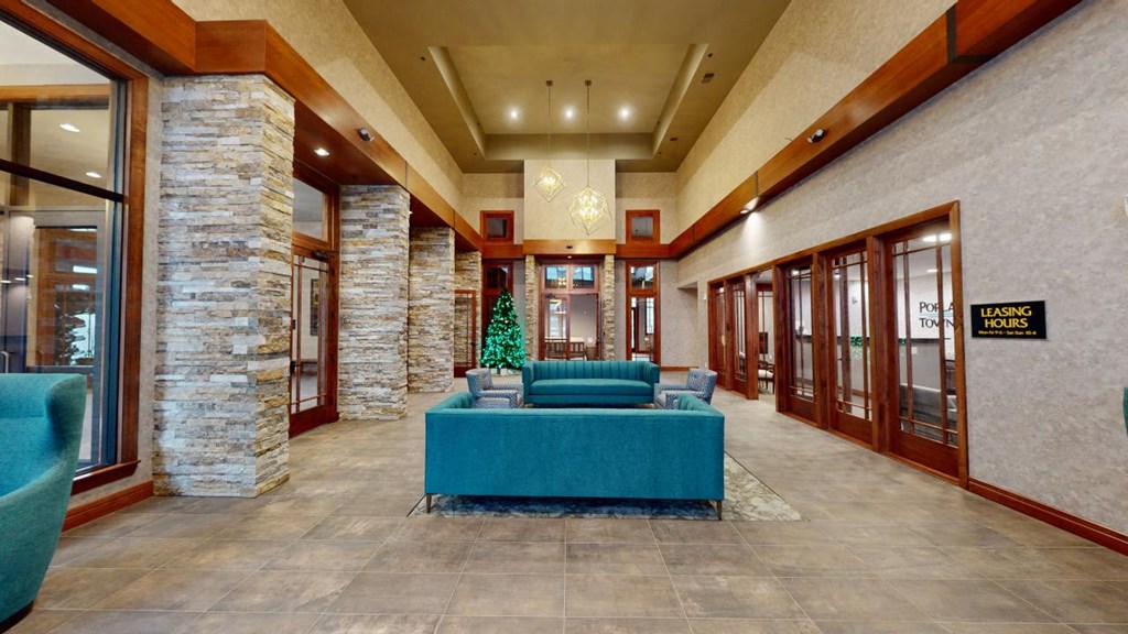 A reception area with a blue table and a stone pillar.