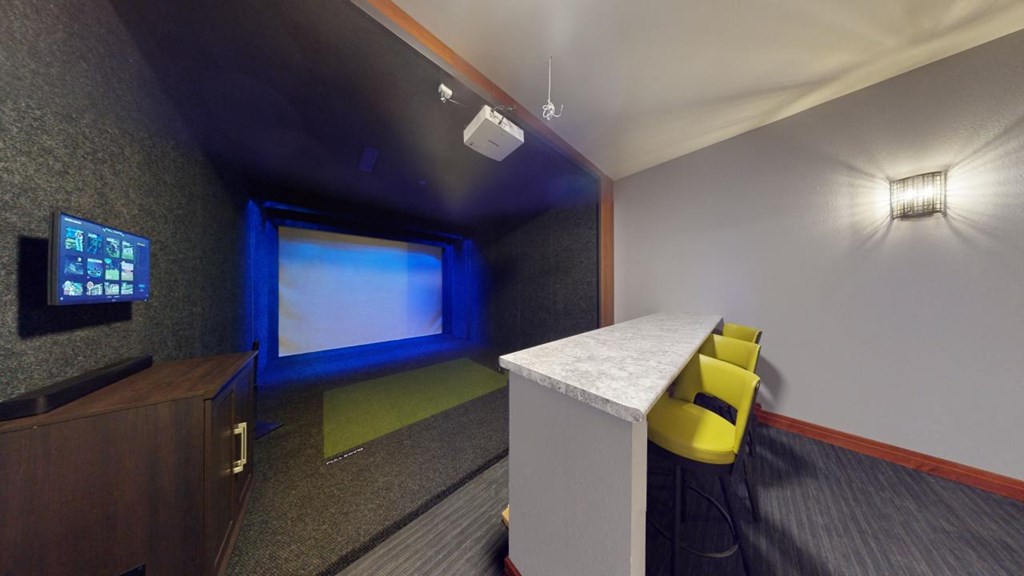 A room with a projector screen and a yellow chair.