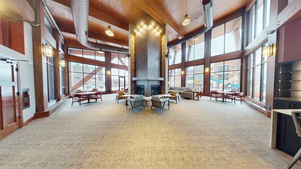 A large open room with a fireplace and lots of windows.