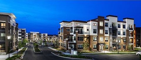 A street view of a residential area with modern apartment buildings.