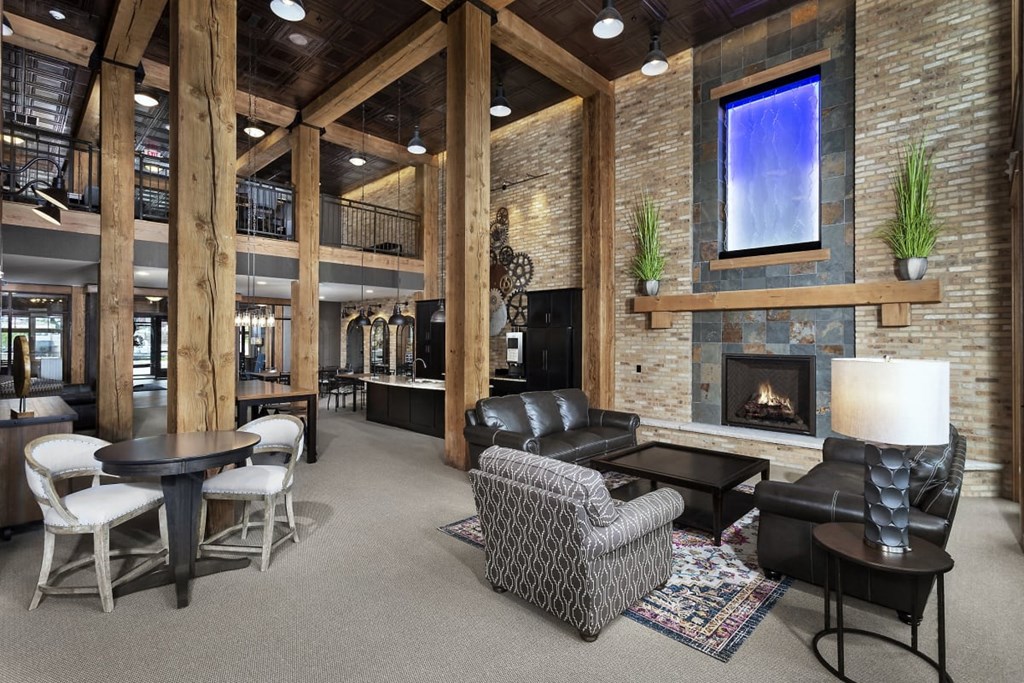 the lobby of a lodge with a fireplace and tables and chairs