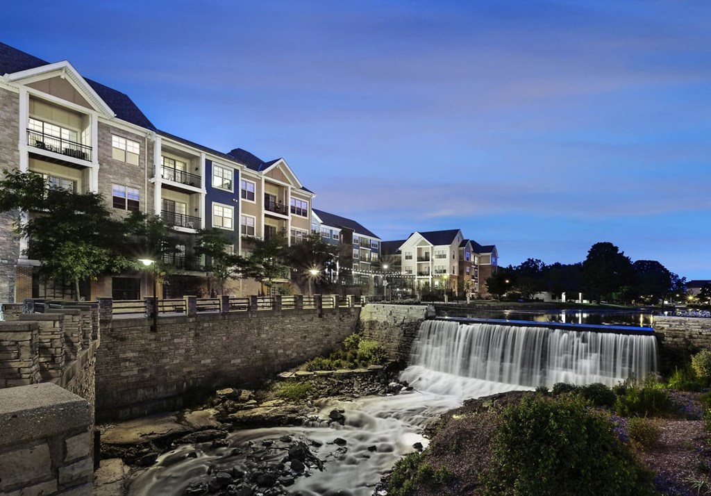 a waterfall in front of a building at night
