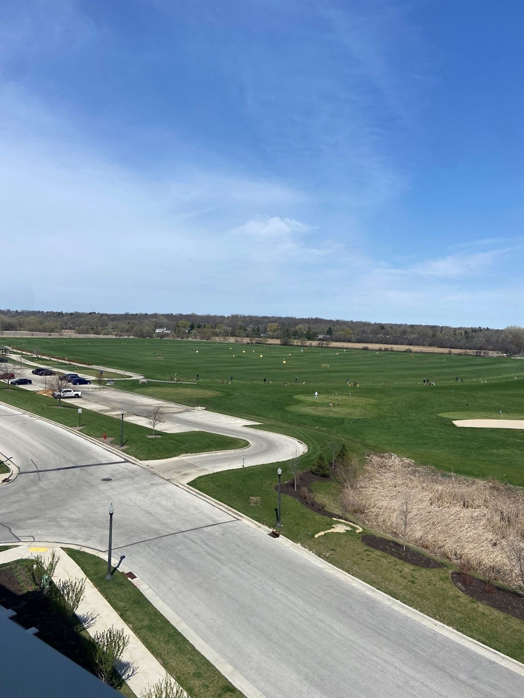 an aerial view of a field of grass with an airport runway in the foreground
