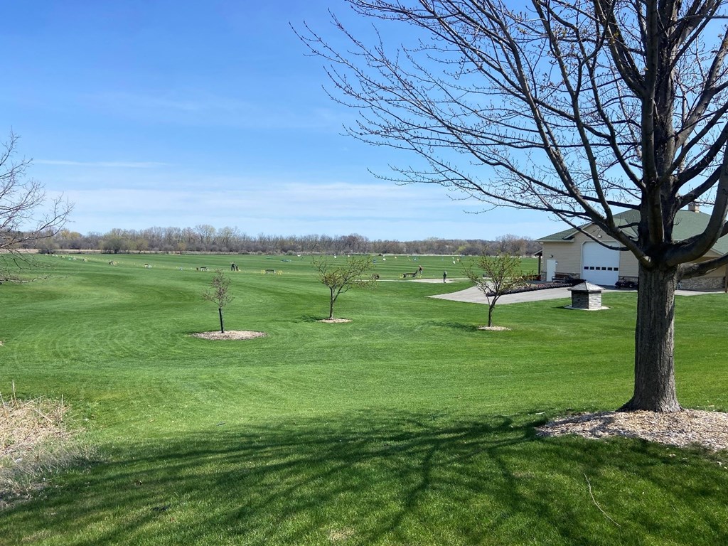 a view of a golf course with trees and a house